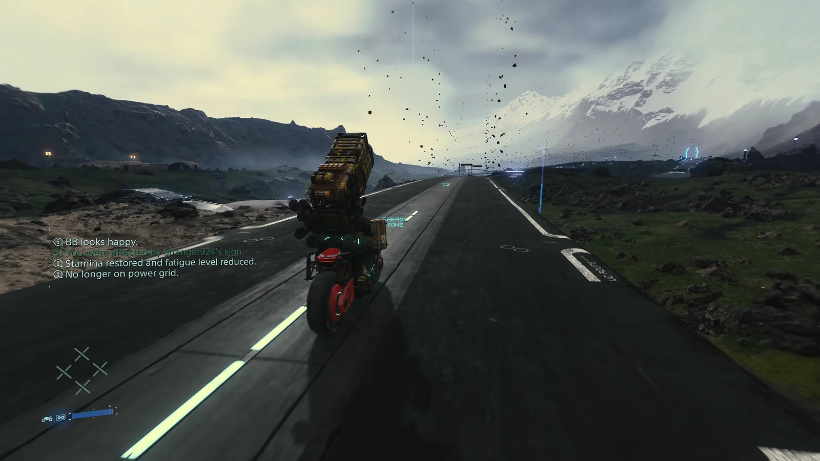 Sam riding a motorcycle on a long highway through a rocky landscape in Death Stranding