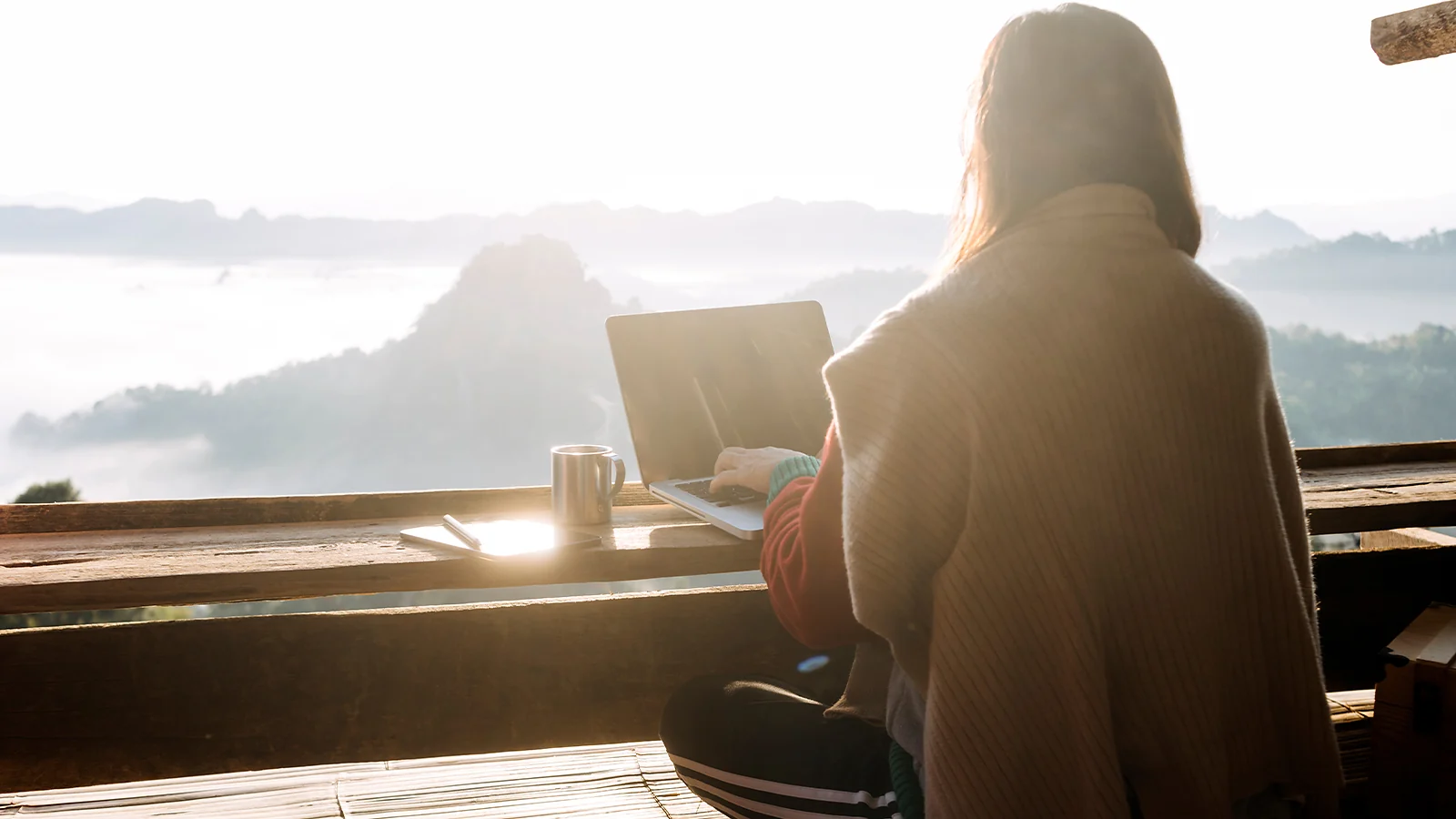 Freelance: working on a laptop outdoors with a scenic mountain view
