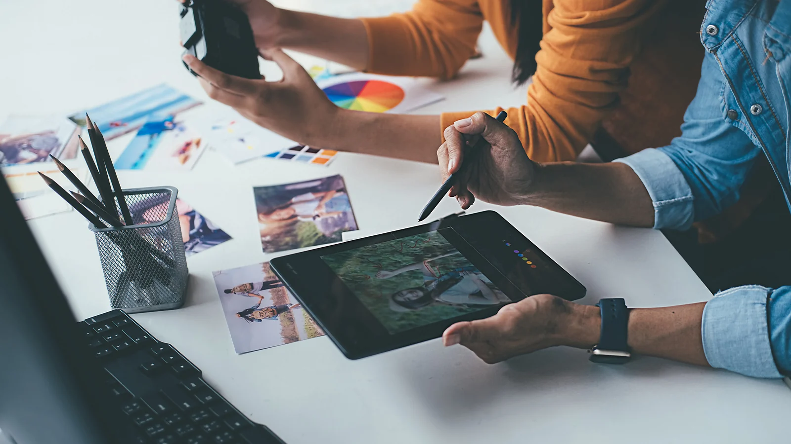 Selling Digital Photos: Photographers editing pictures on a drawing tablet