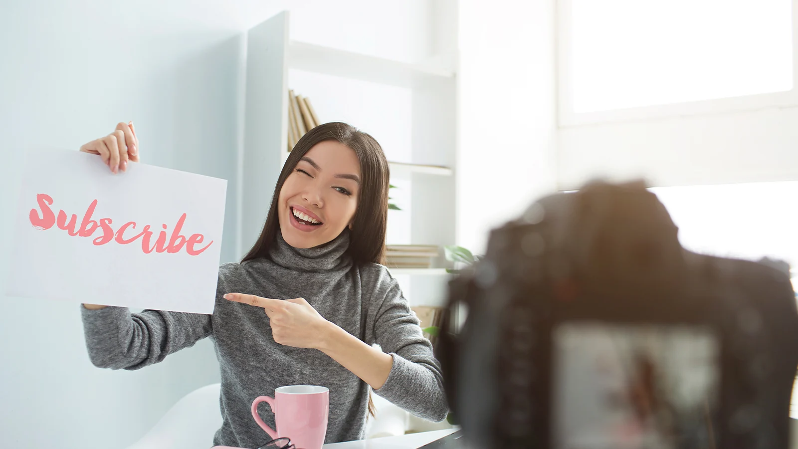 YouTube Monetization: Content creator holding a Subscribe sign for the camera