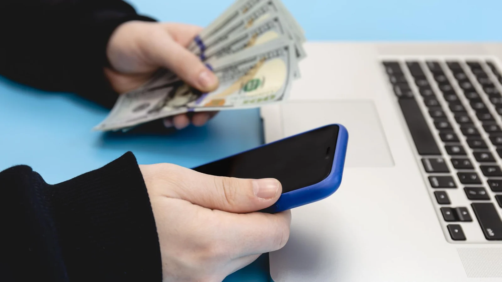 A person holding a phone and money