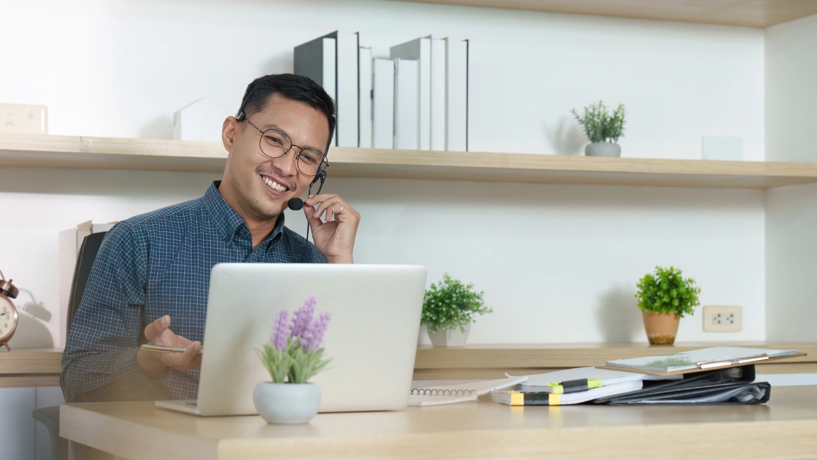 Person with a laptop and headset at a home desk, set up for a remote Amazon customer service shift