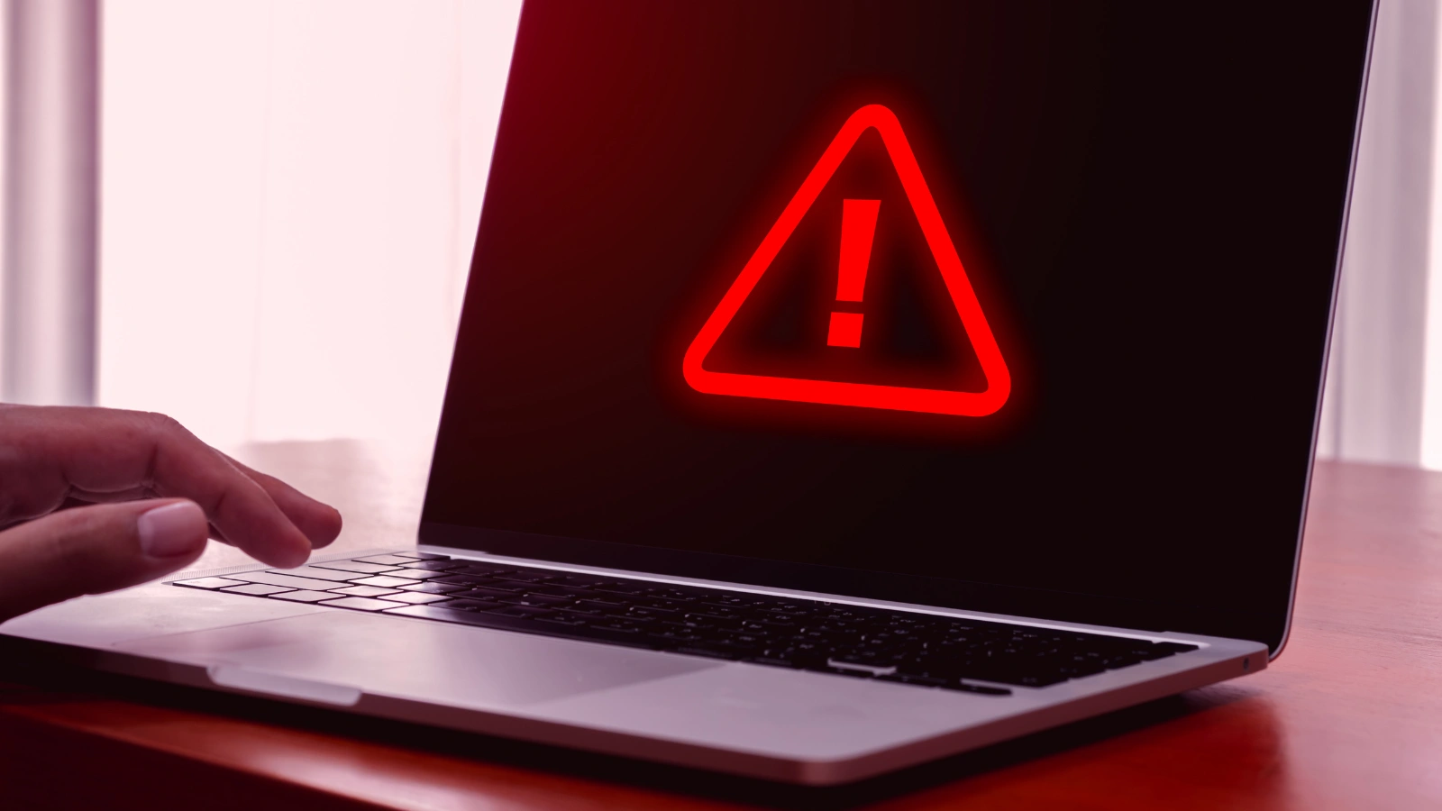 A laptop with a red warning sign on the screen
