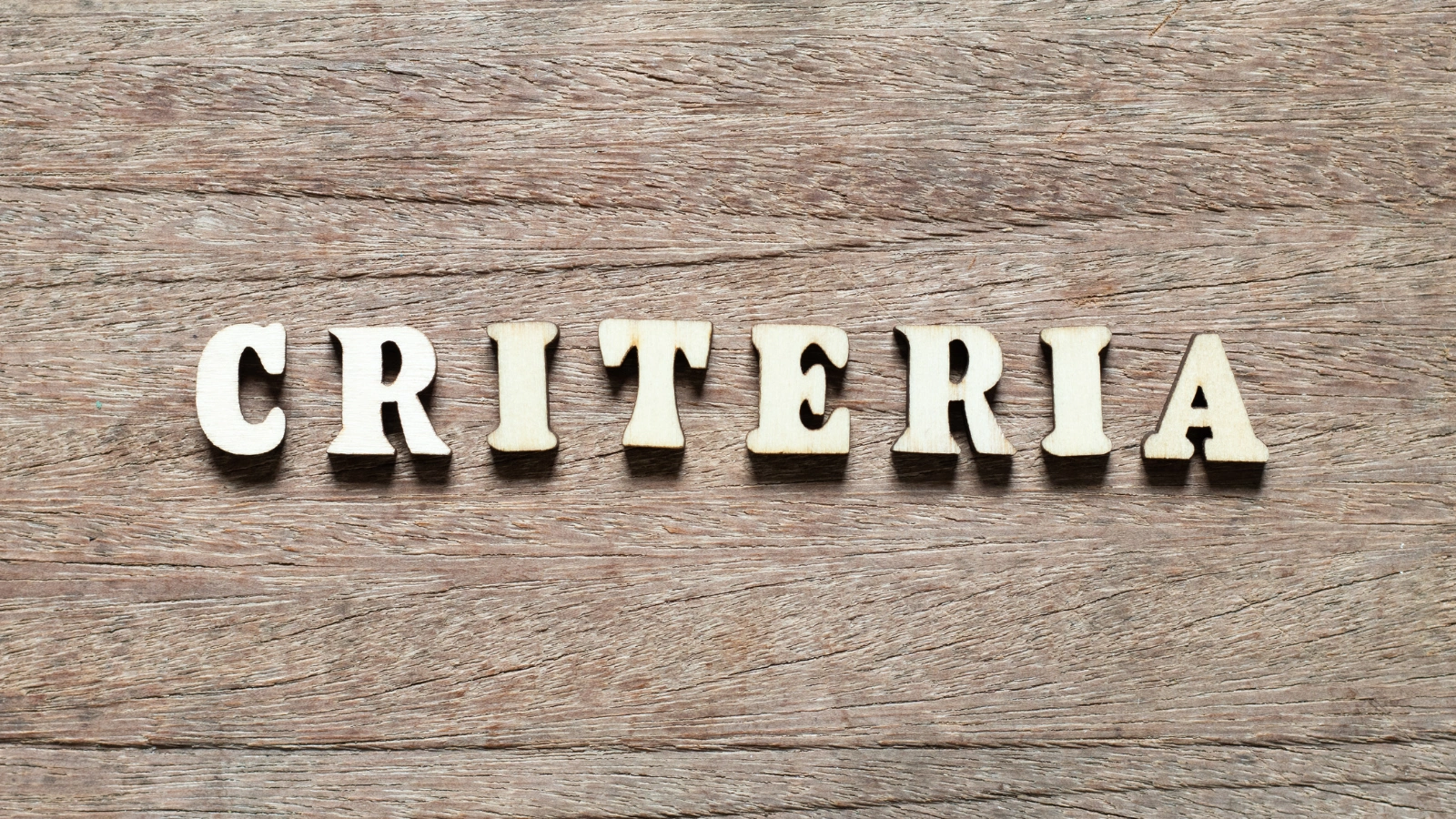 A word ‘Criteria’ in a wooden-looking background