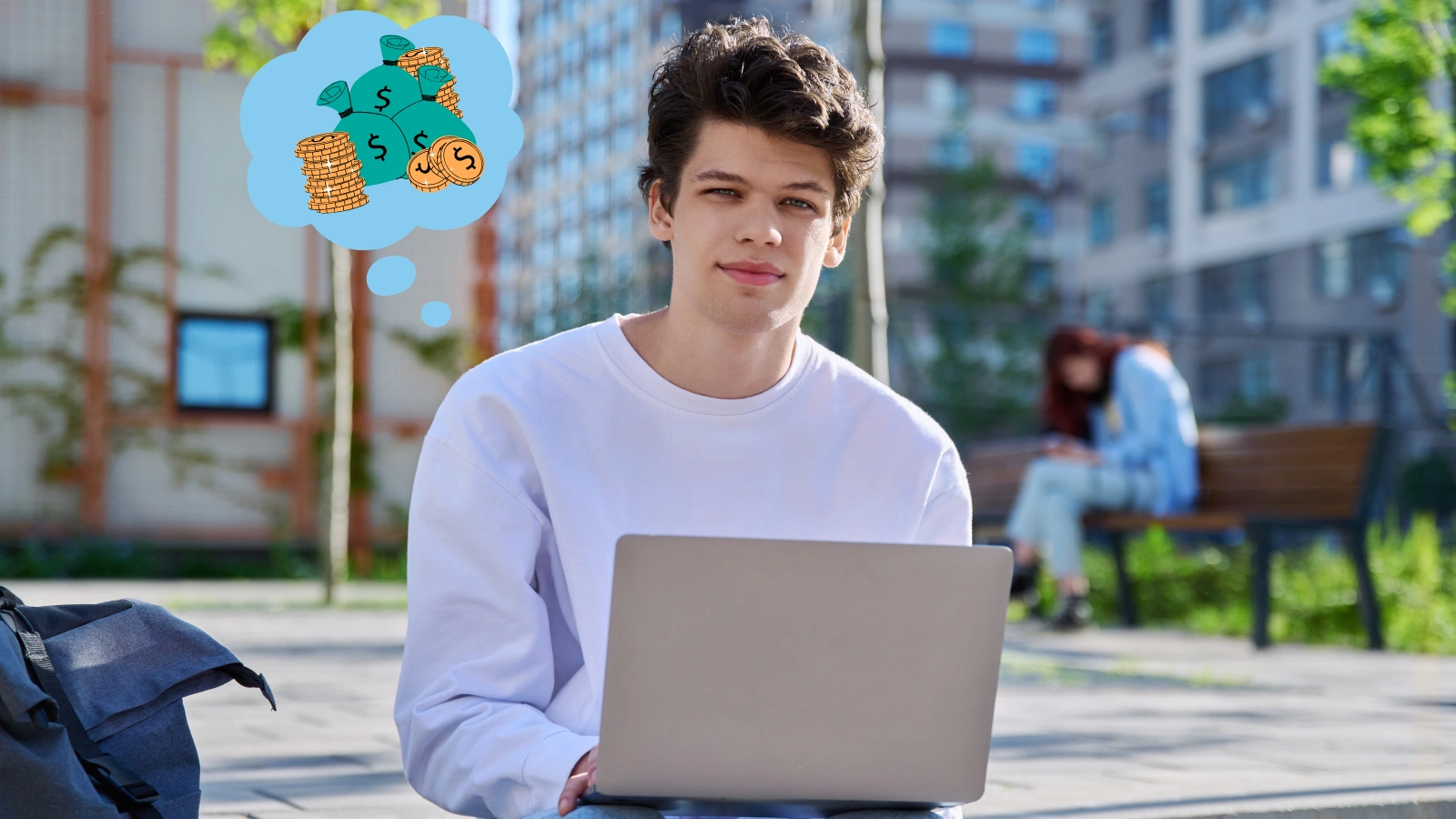 A young person sitting with a laptop in his lap