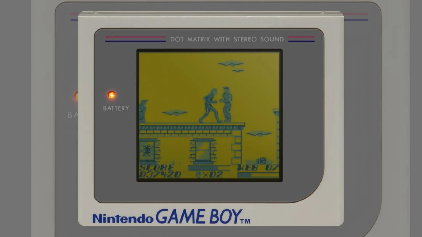 Spider man fighting enemies on a rooftop shown on an old Game Boy screen