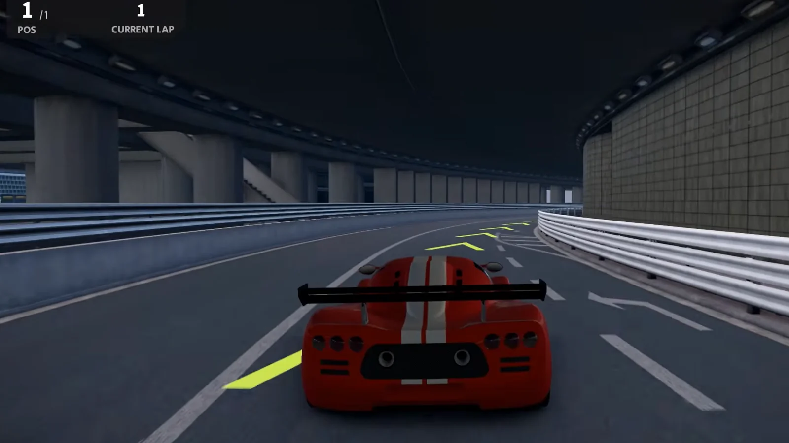 A red race car speeds along a modern racing circuit.