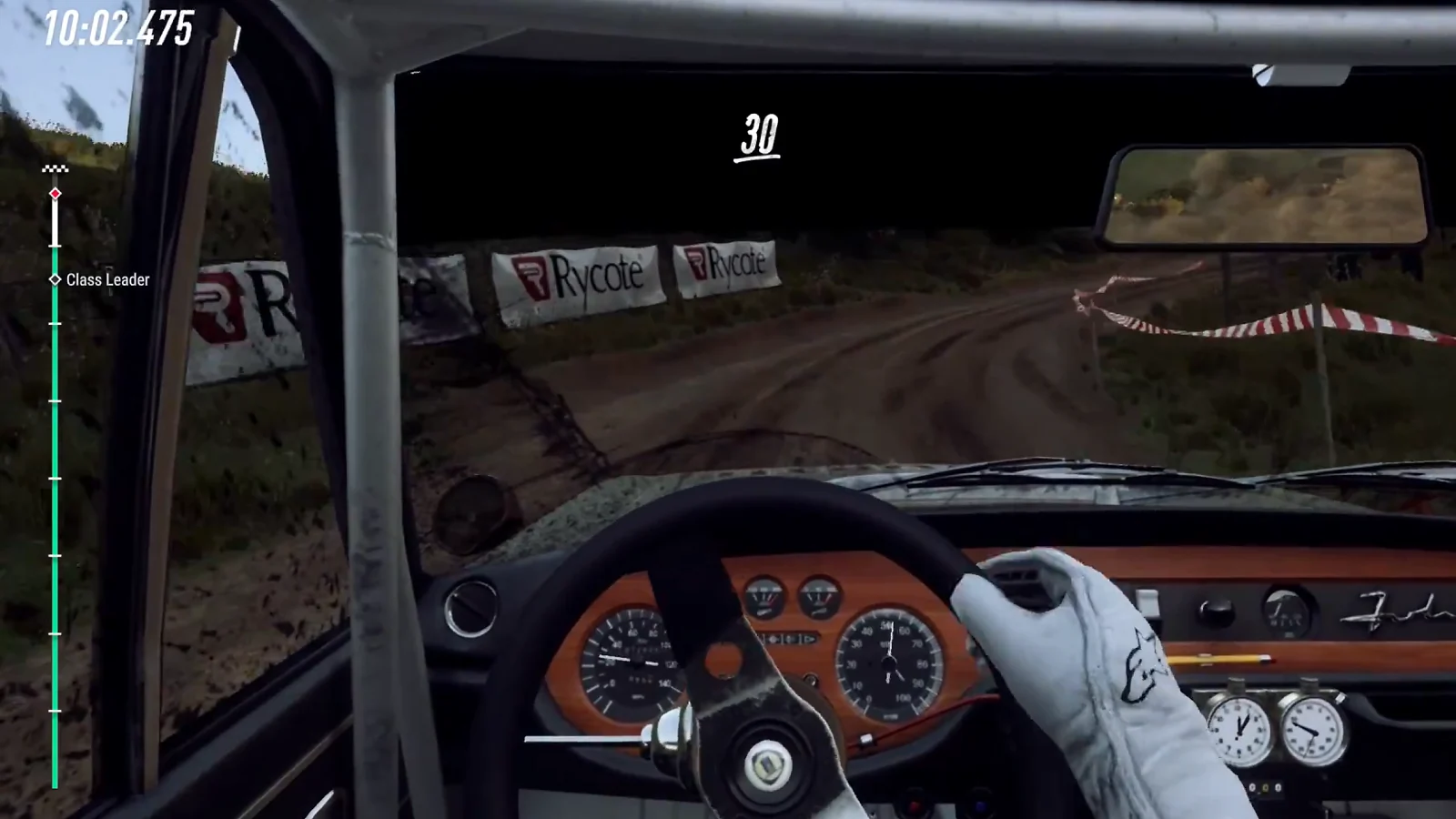 Cockpit view of a rally car driving on a winding dirt road