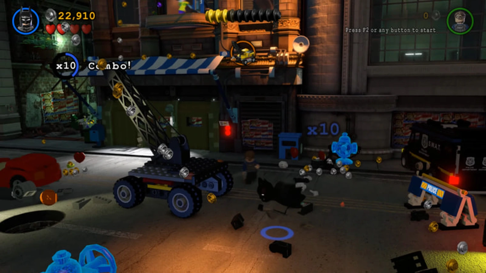 Batman smashes objects on a Gotham street at night next to a crane truck and a SWAT van, earning a x10 combo