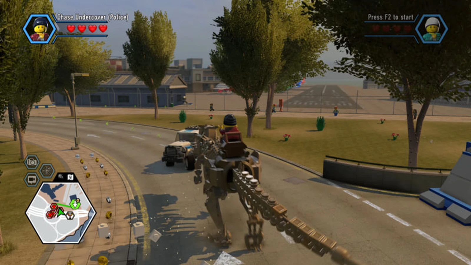 Chase McCain rides a giant robot walker down a city road toward a parked truck near an airfield