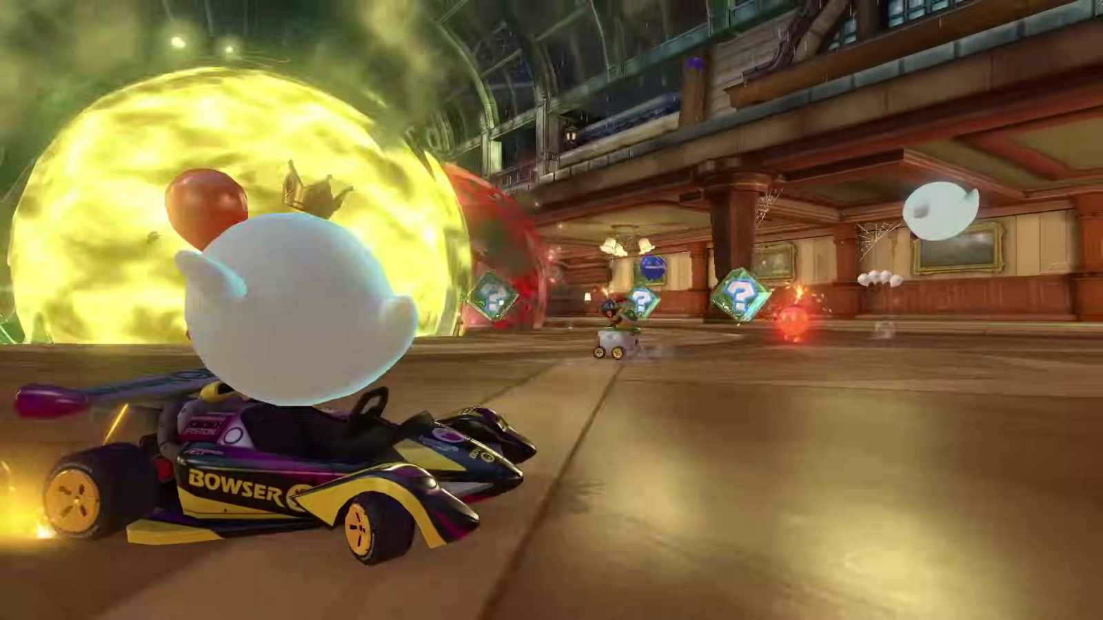 Mario Kart 8 Deluxe bowser kart racing through indoor course with item boxes